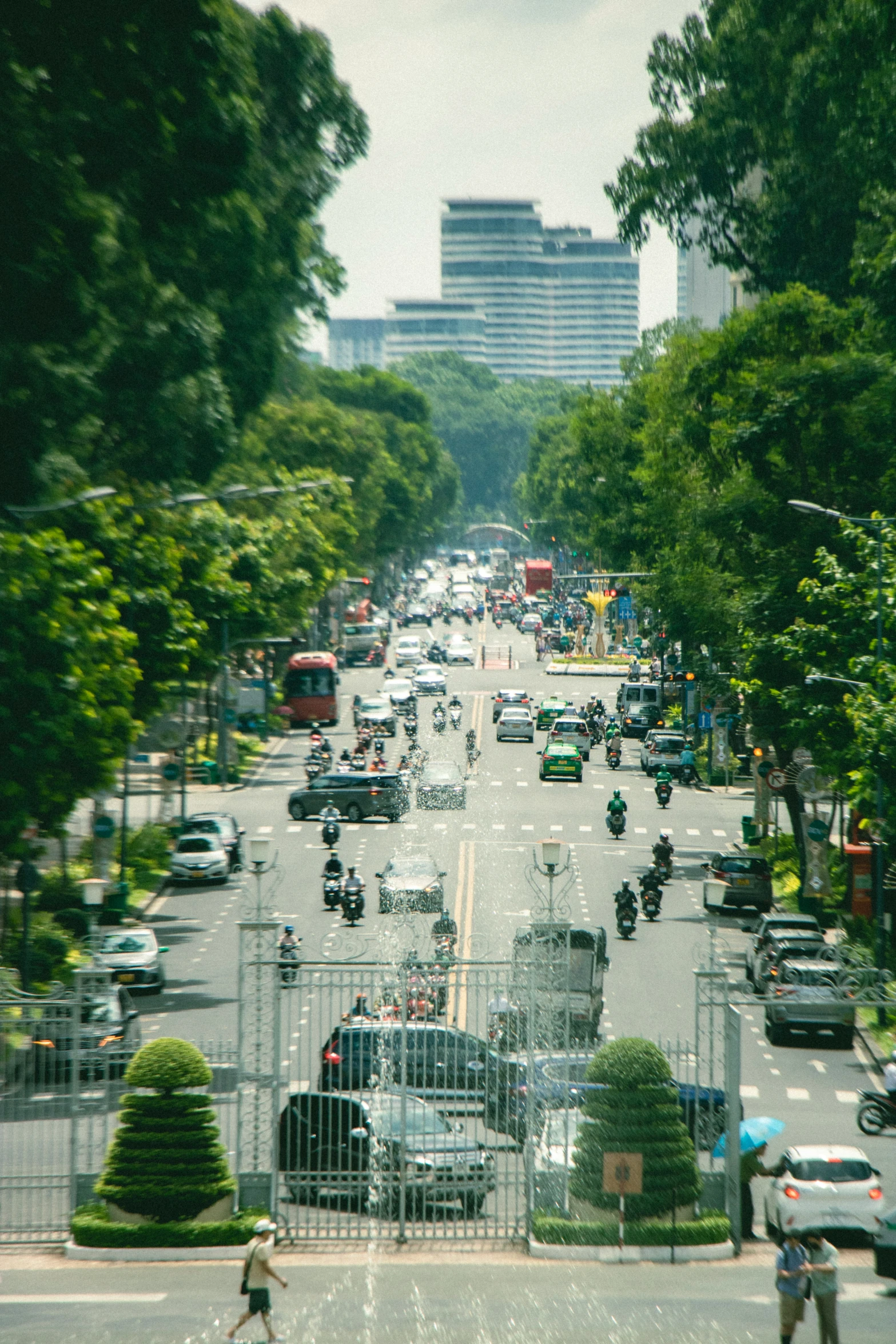 two people on a bicycle are riding down the road