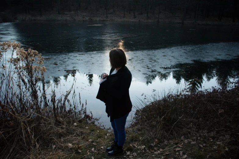 woman standing near a body of water at night