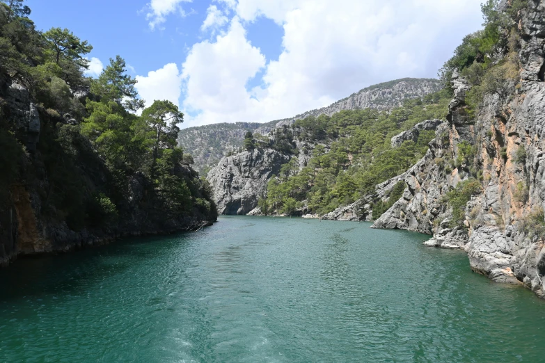 a narrow river between two cliff sides with green water