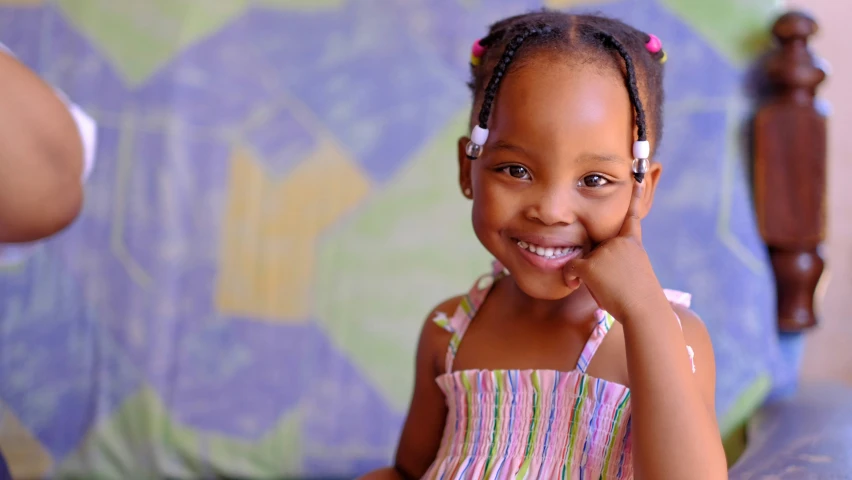 a little girl smiling and wearing a dress with head pieces