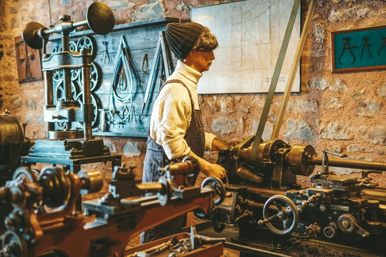 a person working in a machine shop next to an old sign