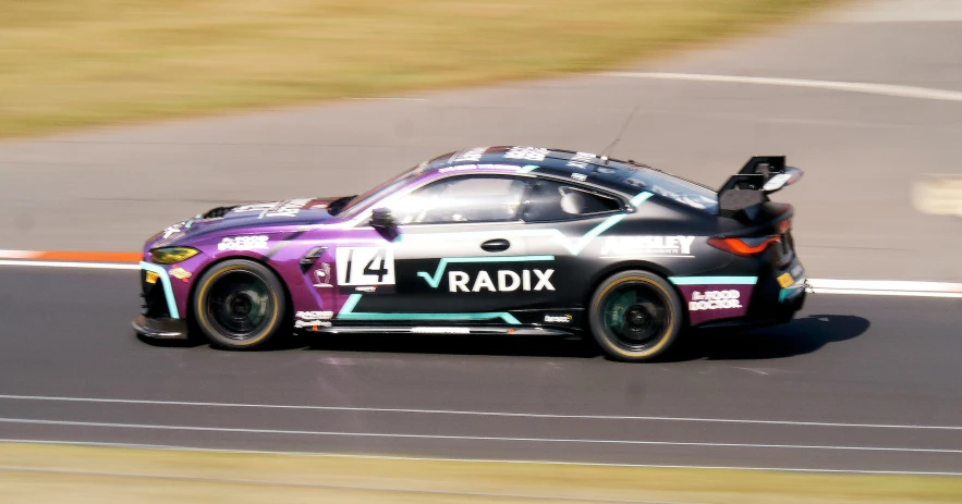 a purple car driving down a track on a race