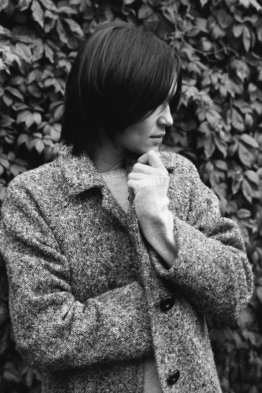 a black and white po of a young man leaning on a bush