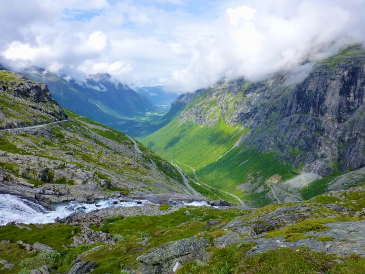 a stream in the middle of a lush valley