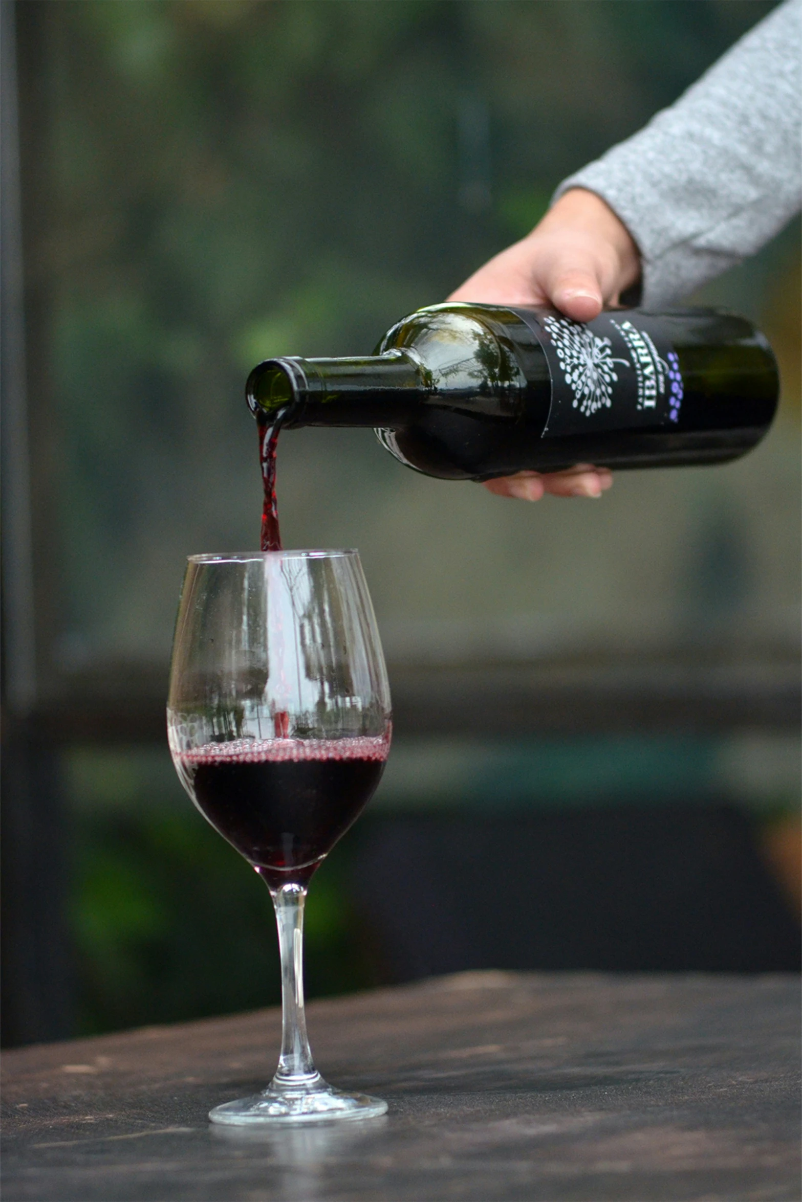 someone pouring wine into a wine glass from a bottle