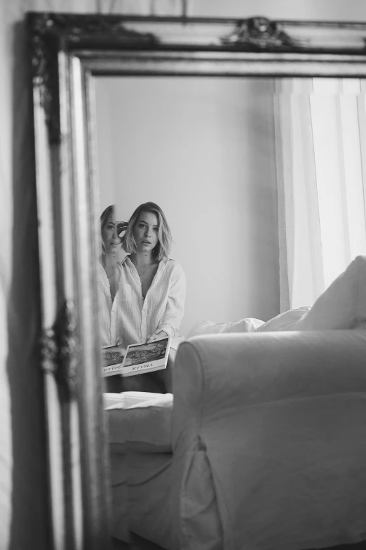 woman brushing her teeth in front of a mirror