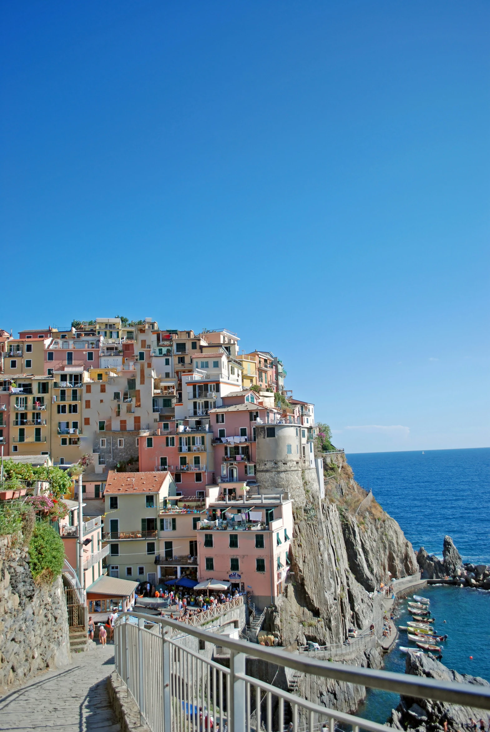 a street next to the ocean with houses on the hill above