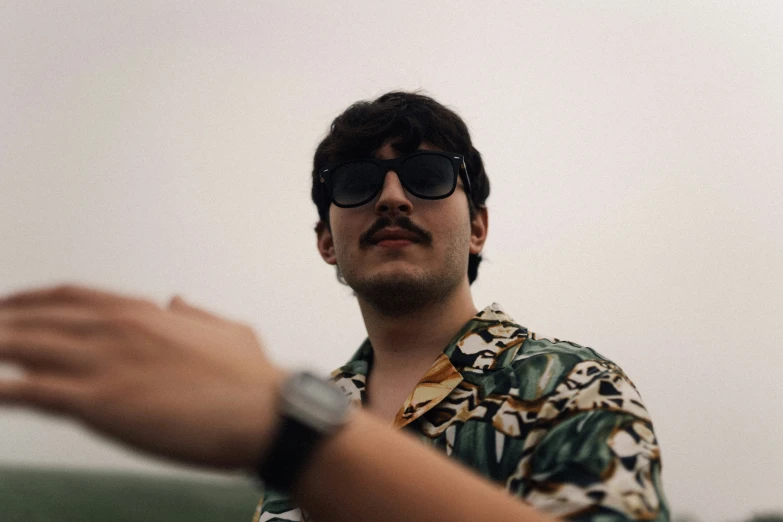 a man wearing shades is tossing the frisbee to someone