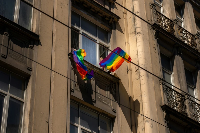 a rainbow kite flying on the side of a large building