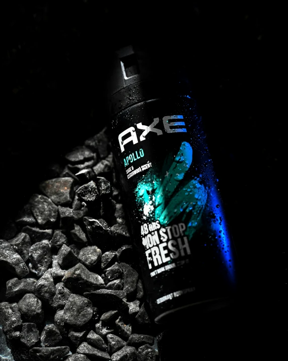 a bottle of axe next to rocks