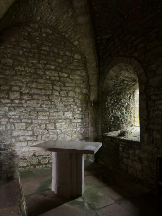 an arch in the wall is lit by sunlight