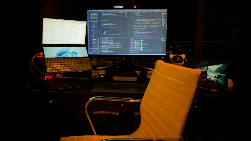 an office desk with three computers sitting next to each other