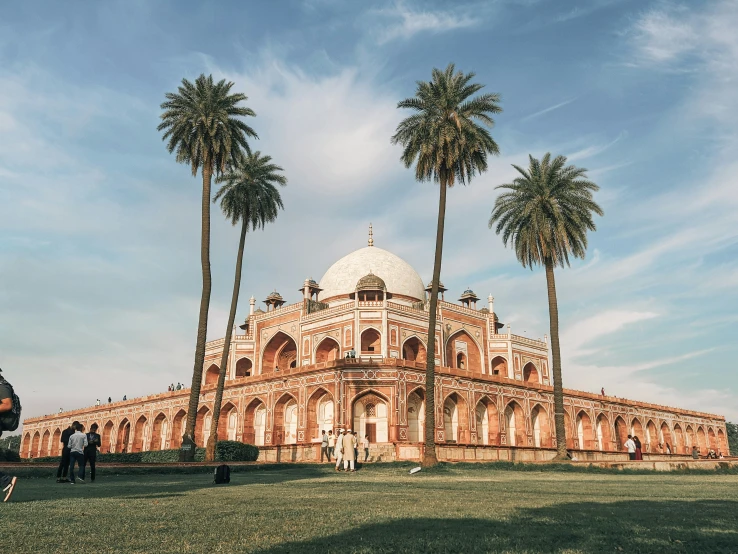 a large building sitting next to two palm trees