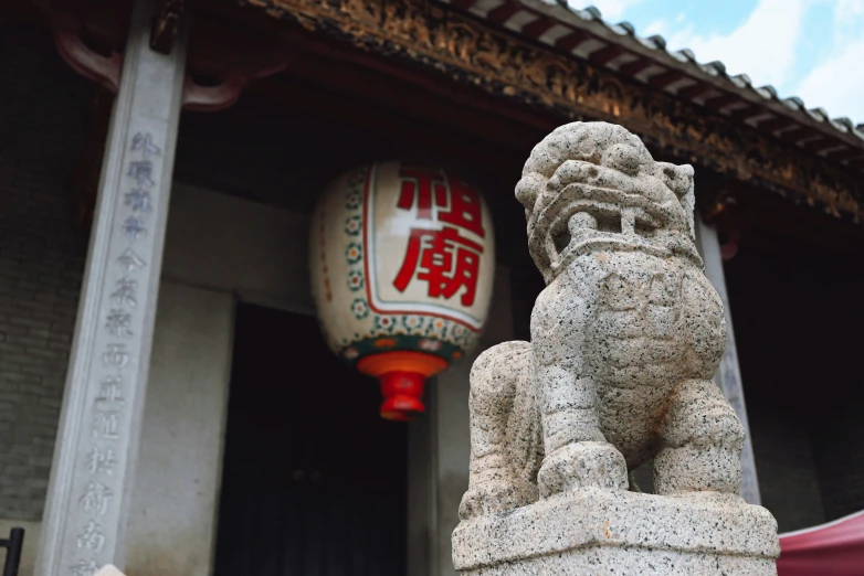 a stone lion statue outside of a building