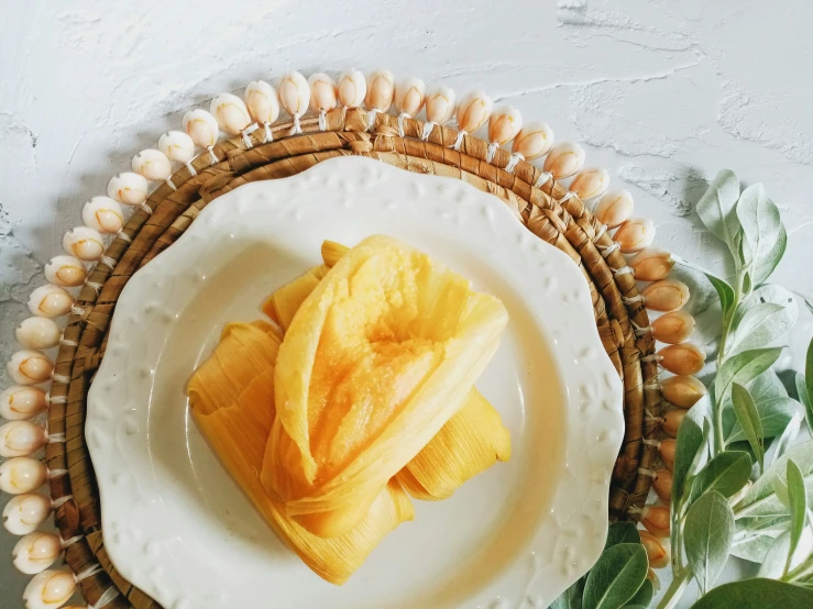 yellow peeled fruit sitting on top of a white plate