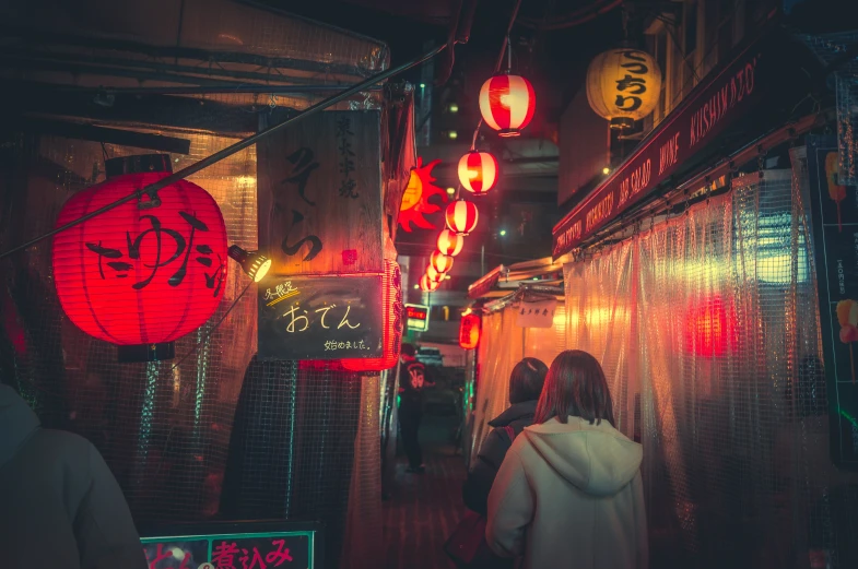 a dark street with chinese lanterns hanging above it