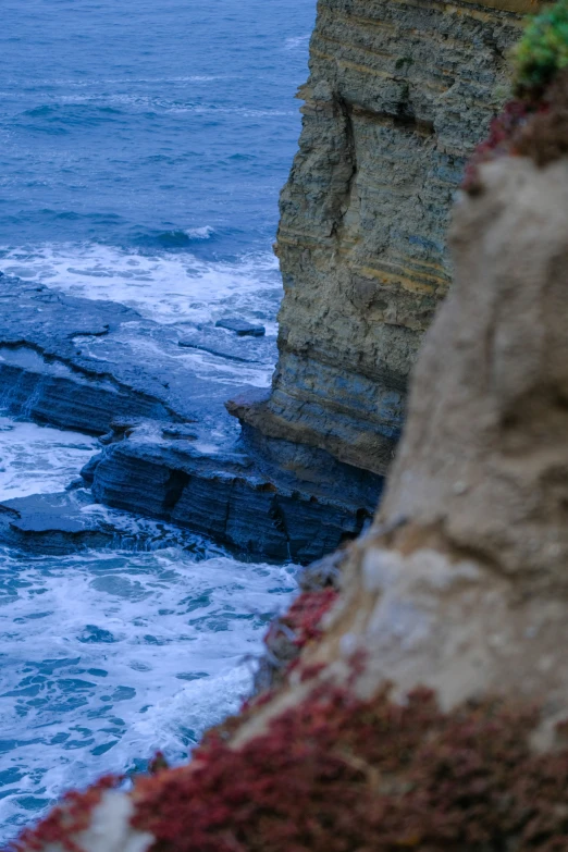 a sea cliff covered with water next to an ocean