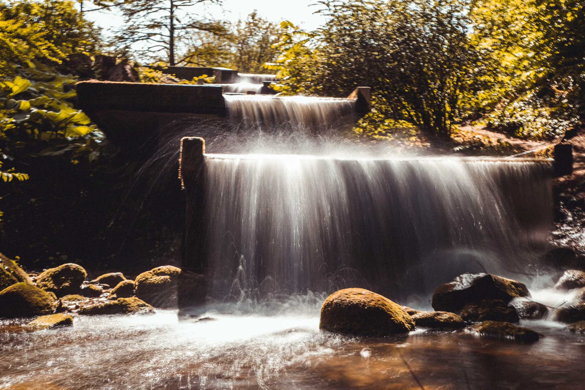 a small waterfall gushing water and a couple rocks