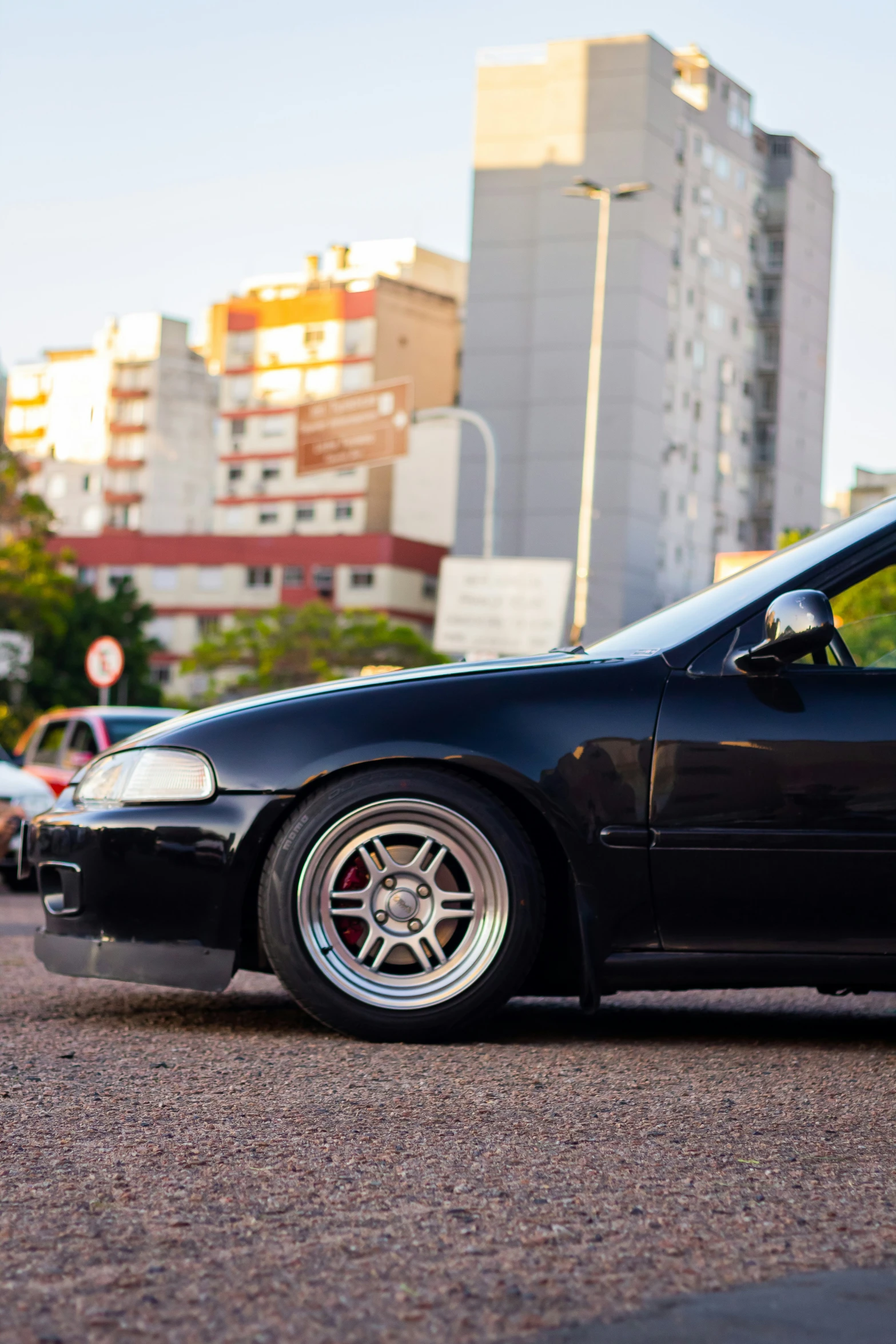 a car parked on the street with buildings in the background