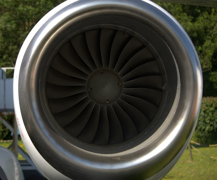 an airplane engine in a grassy area with trees in the background