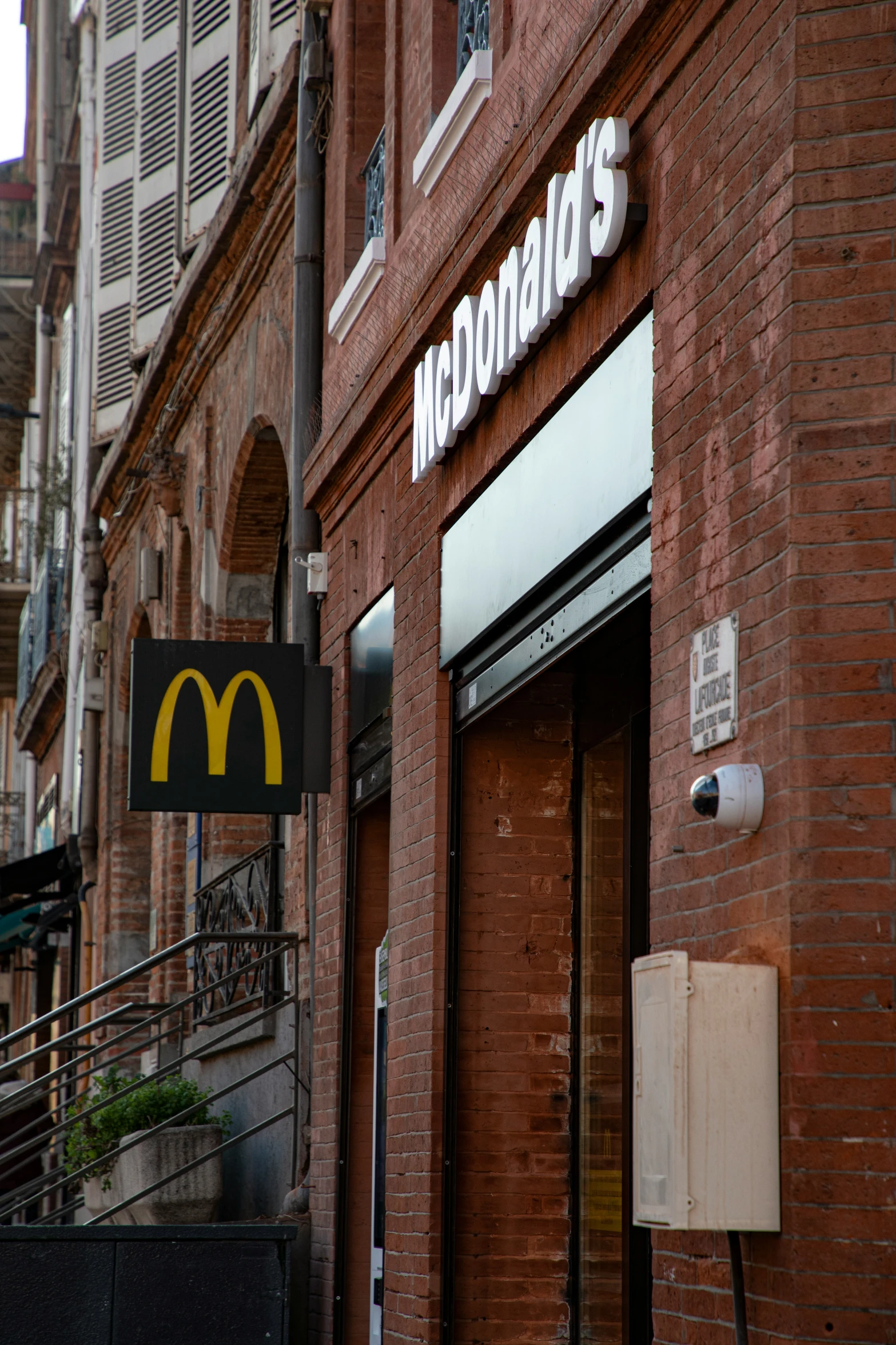 the front of a brick restaurant with sign for mcdonald's