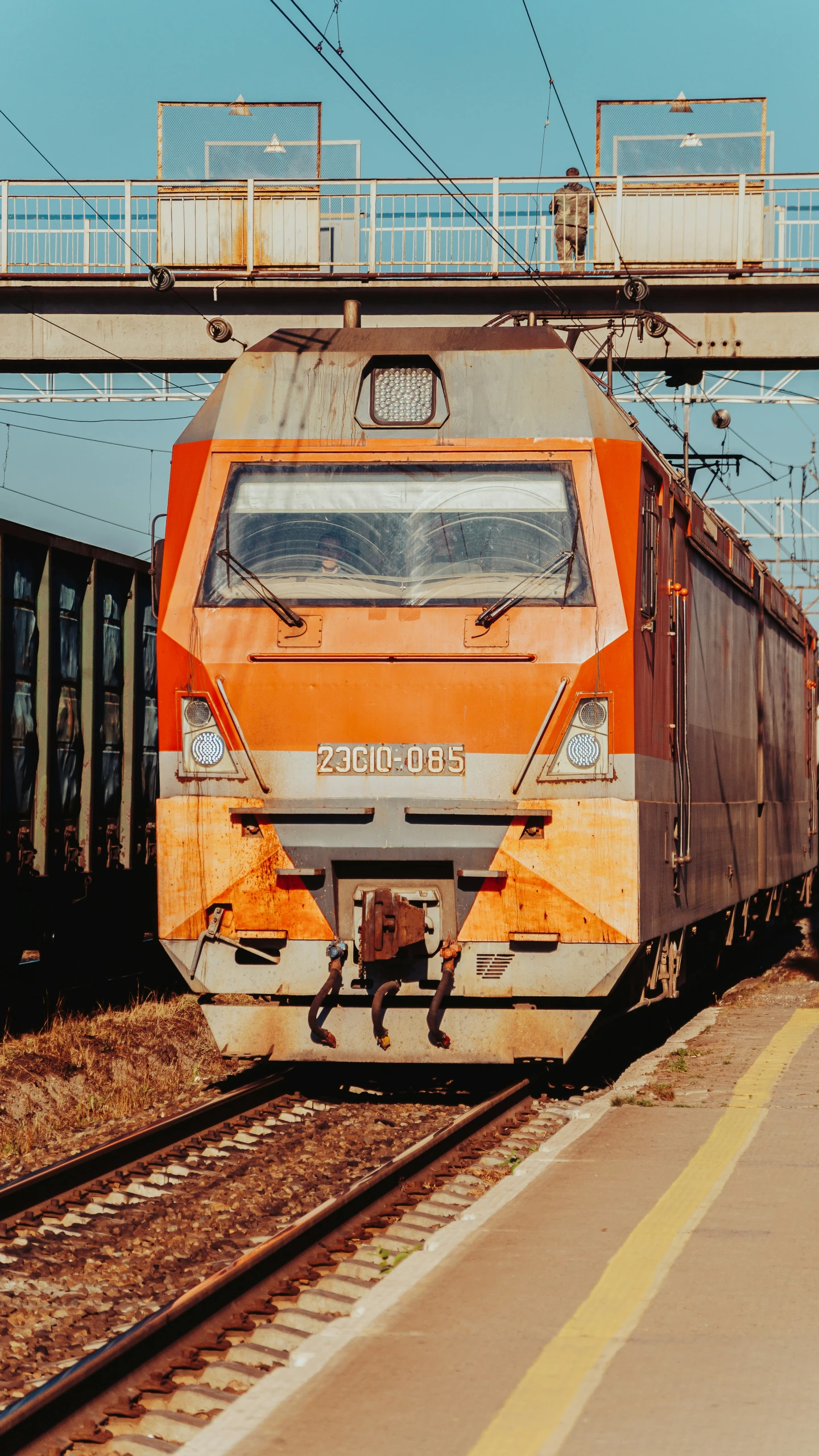 an orange and white train stopped at a station