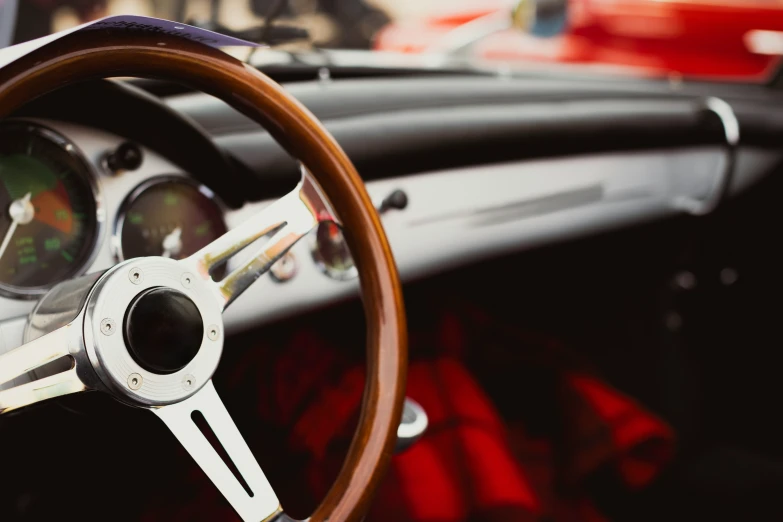 the steering wheel and dashboard of an old classic car