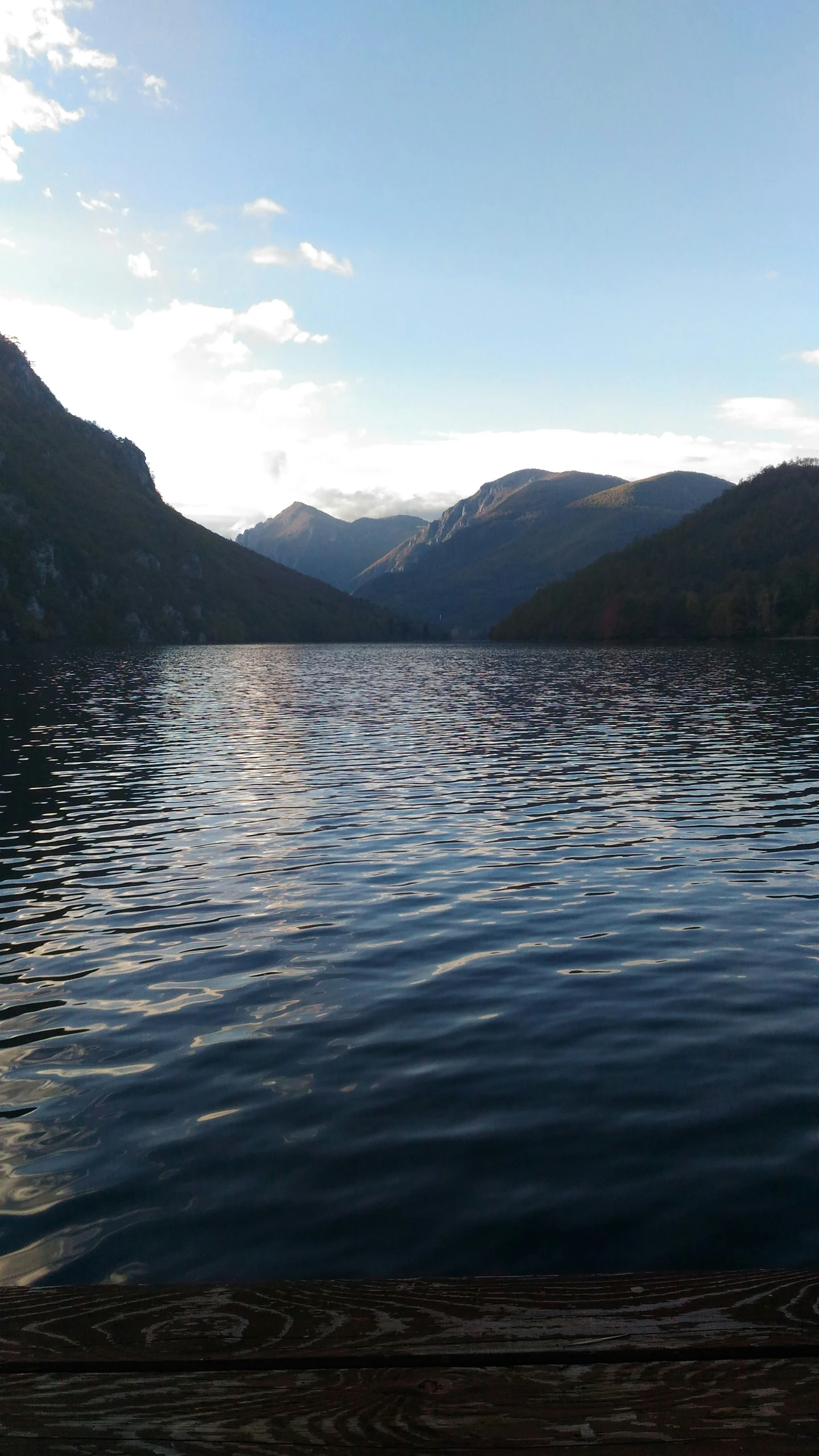 the view of mountains and water from the end of a dock