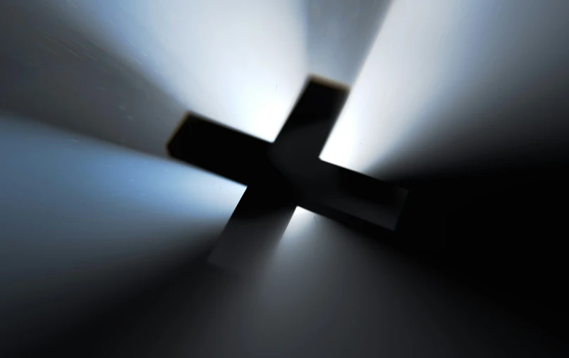 a cross is glowing against the wall of an empty room