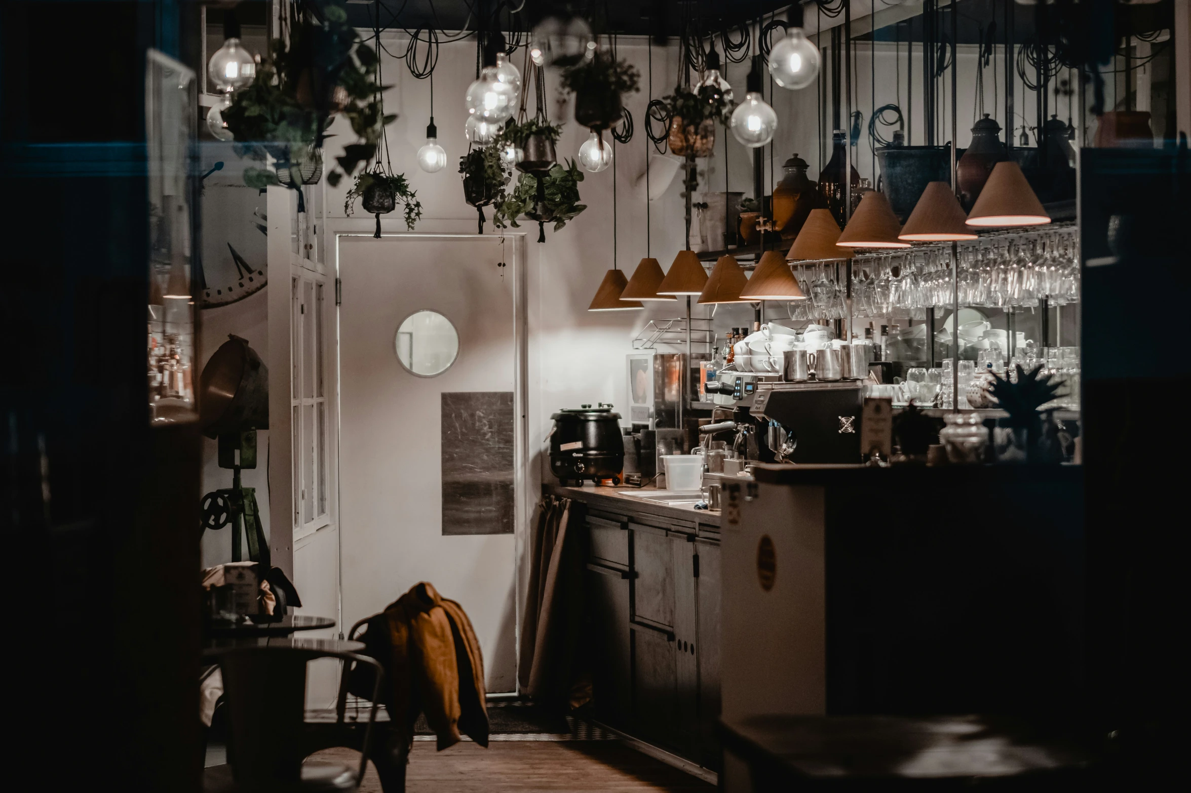 a kitchen filled with lots of lights next to a bar