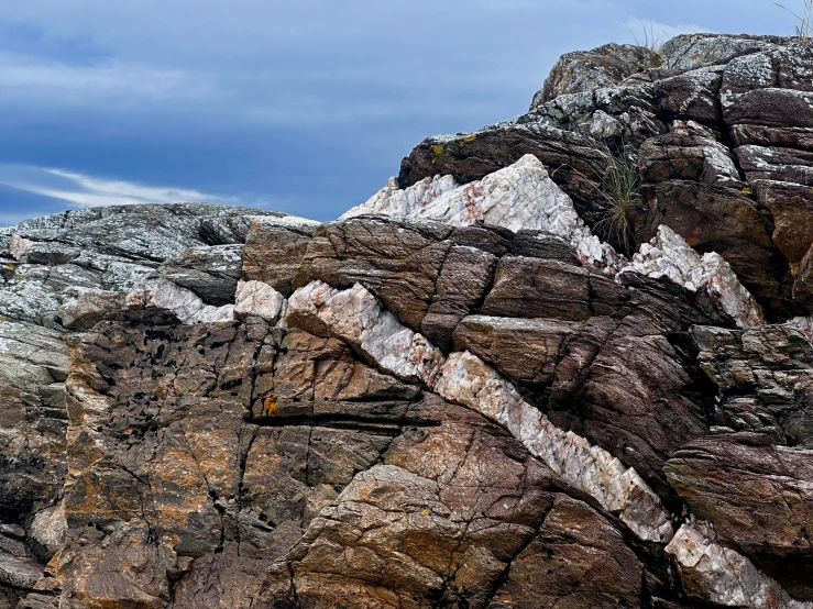 a large rocky mountain with some small clouds above