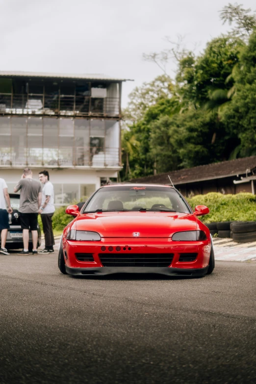 a car parked on the side of a road with people looking on