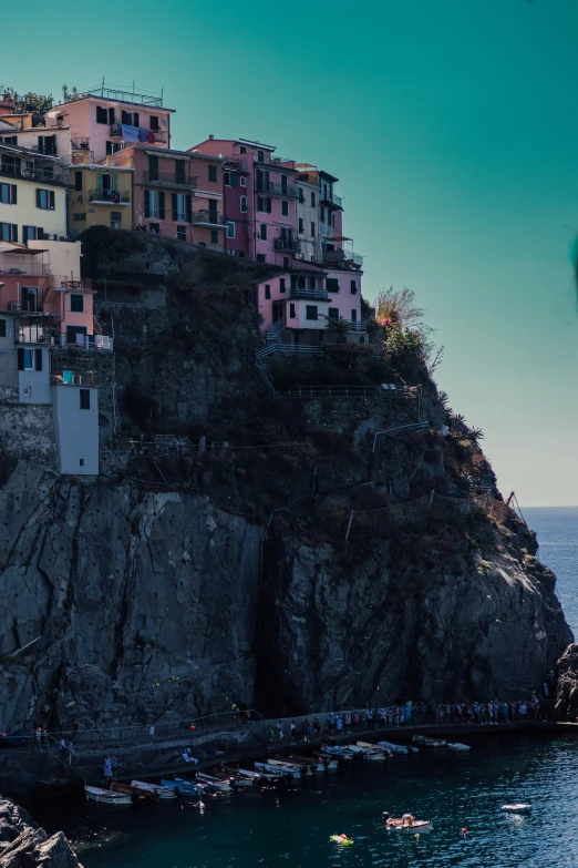 a large house on a rocky hillside above a body of water