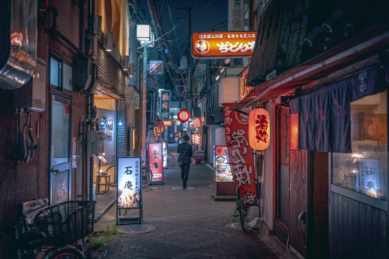 a city alley with lighted signs and people walking on it