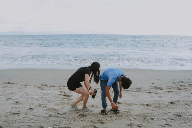 two people on the beach in front of water