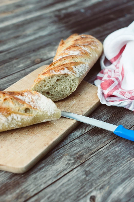 a wooden  board with bread on it and blue spatula