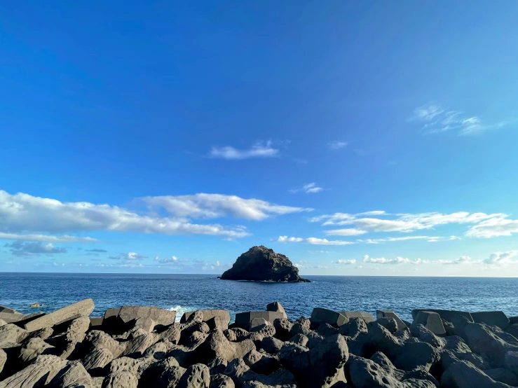 there is a rock cliff on a lake shore