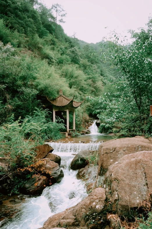 a waterfall on the side of a hill with trees