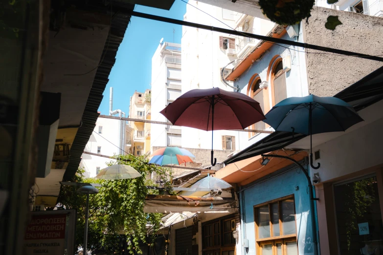 many umbrellas are hanging over an alleyway