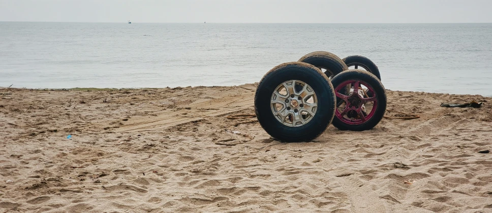 two large tires parked on top of sandy beach