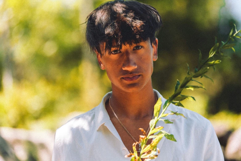 a man holds up a plant in the sun