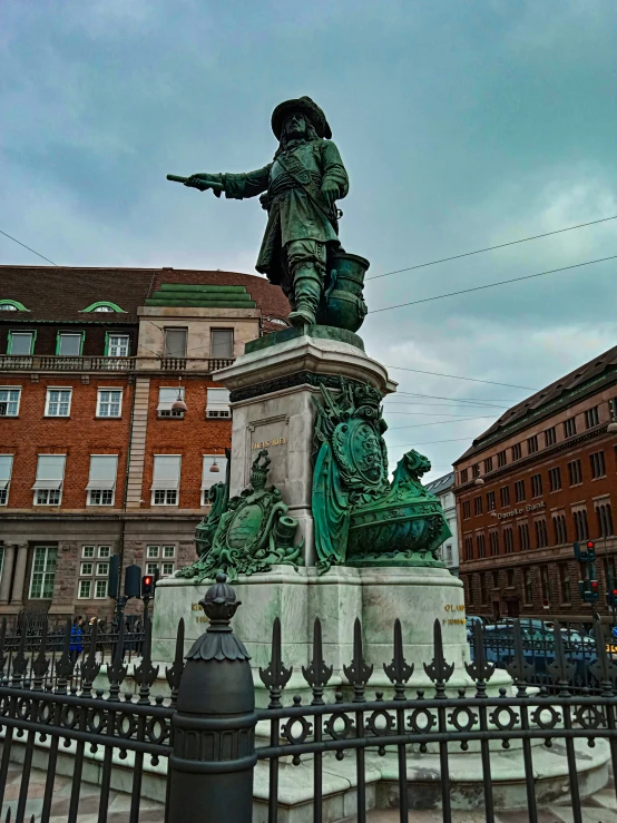 a statue of an old soldier with a gun on top of the monument in a city center