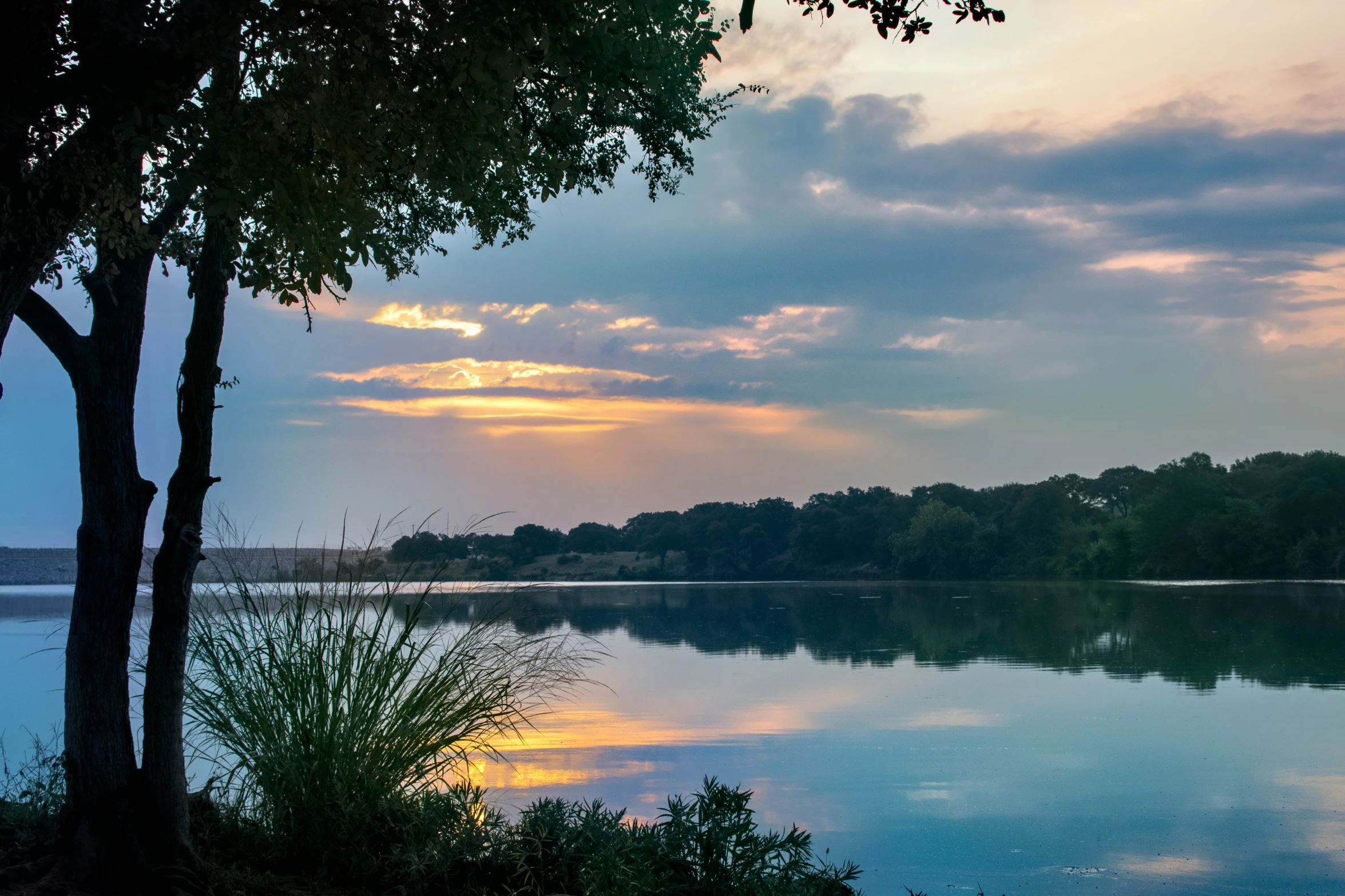 an image of a lake at dusk taken from the shore