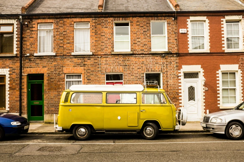 a van parked by a house with a van next to it