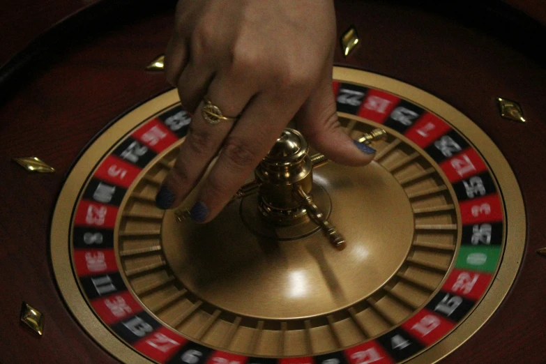 a person pressing down on a casino wheel