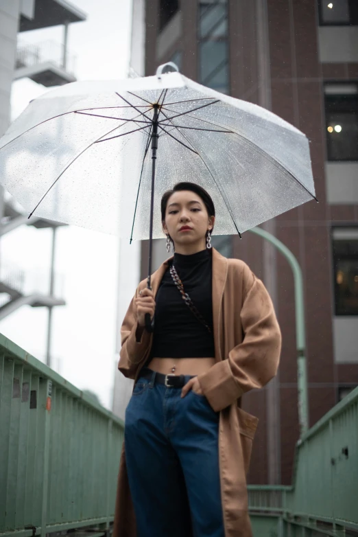 a woman standing in front of a building holding an umbrella