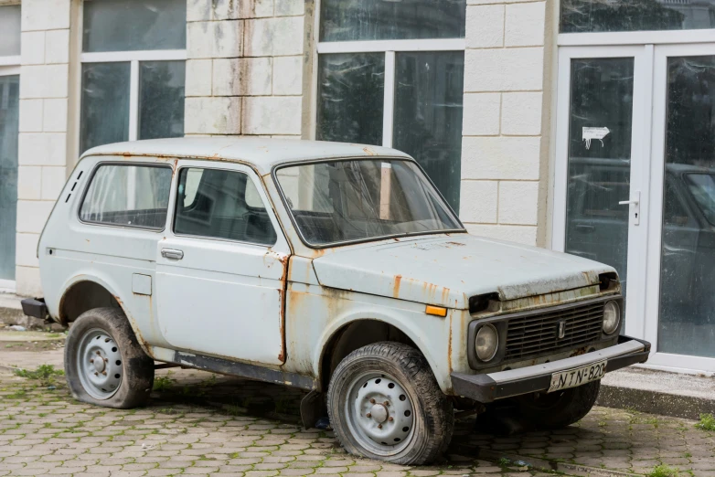 an old rusted and scratched up truck on the street