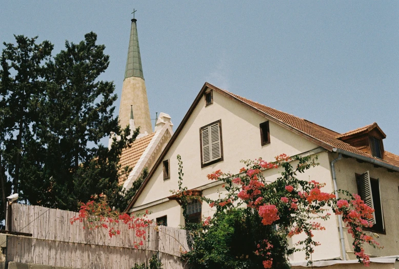 a house with a clock tower standing next to a fence