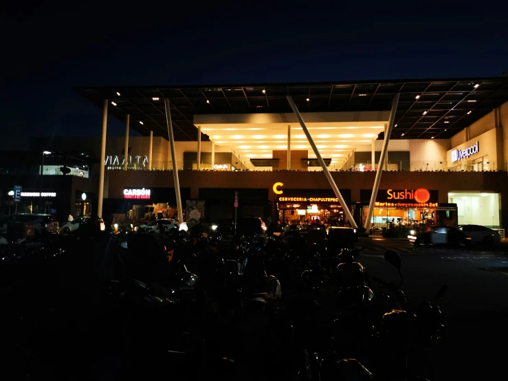 people and motorcycles are parked in front of a building