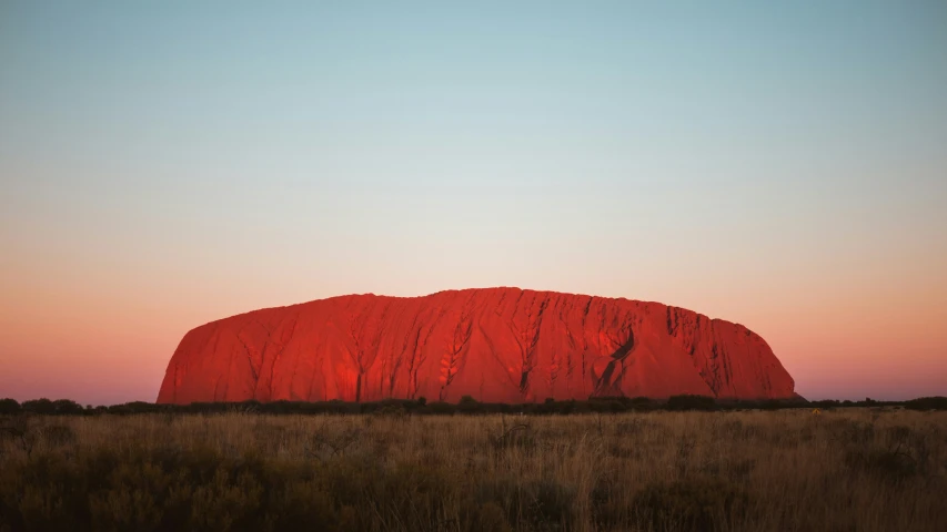 a large rock lit up by the setting sun